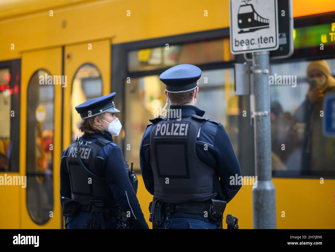 Dresden, Germany. 23rd Nov, 2021. Police officers stand at a DVB tram stop in Dresden city centre. The Dresden police department is monitoring compliance with the new Corona rules on a daily basis with 50 officers. Accordingly, the focus is on controls of the FFP2 mask obligation in public transport as well as the exit restrictions for unvaccinated persons in hotspot areas. Credit: Robert Michael/dpa-Zentralbild/dpa/Alamy Live News Stock Photo