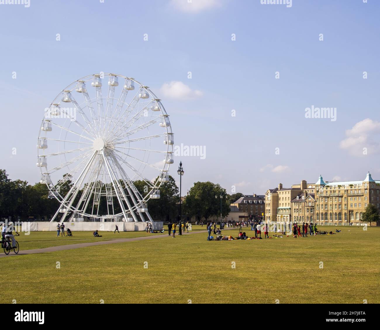 CAMBRIDGE, UNITED KINGDOM - Sep 21, 2021: The Ferris wheel in the middle of an open common with the University Arms Hotel Stock Photo