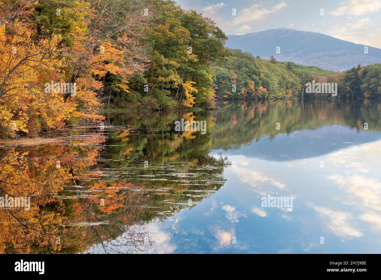 Tranquil autumn scene near Harrisville, New Hampshire. Colorful display of fall foliage alongside Childs Bog Reservoir with mirror image reflection of Stock Photo