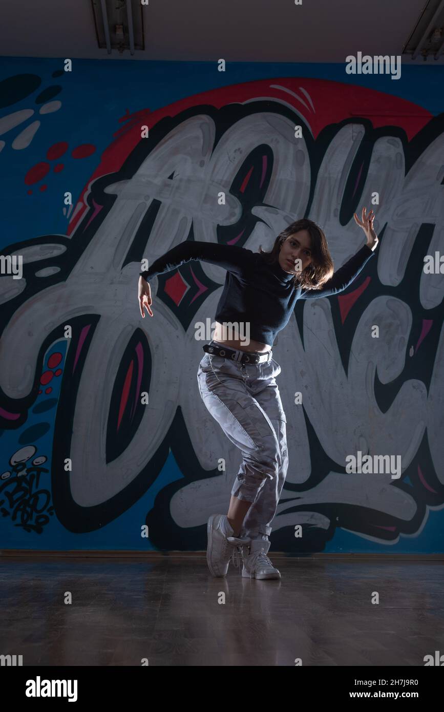 Silhouette of young woman hiphop dancer (breakdancer)dancing on graffiti  studio background. Contrast colors Stock Photo - Alamy, image size:867x1390