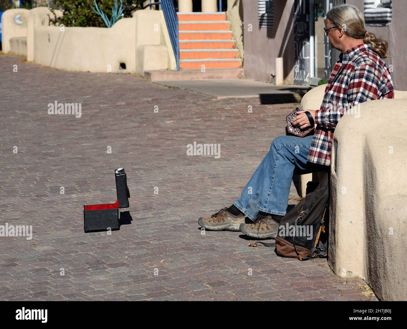 A street musician plays his squeezebox for tips in Taos, New Mexico. Stock Photo