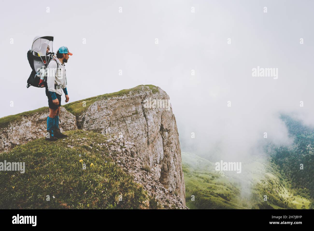 Man father hiking with child in backpack family vacations travel together in foggy mountains healthy lifestyle adventure trip outdoor Stock Photo