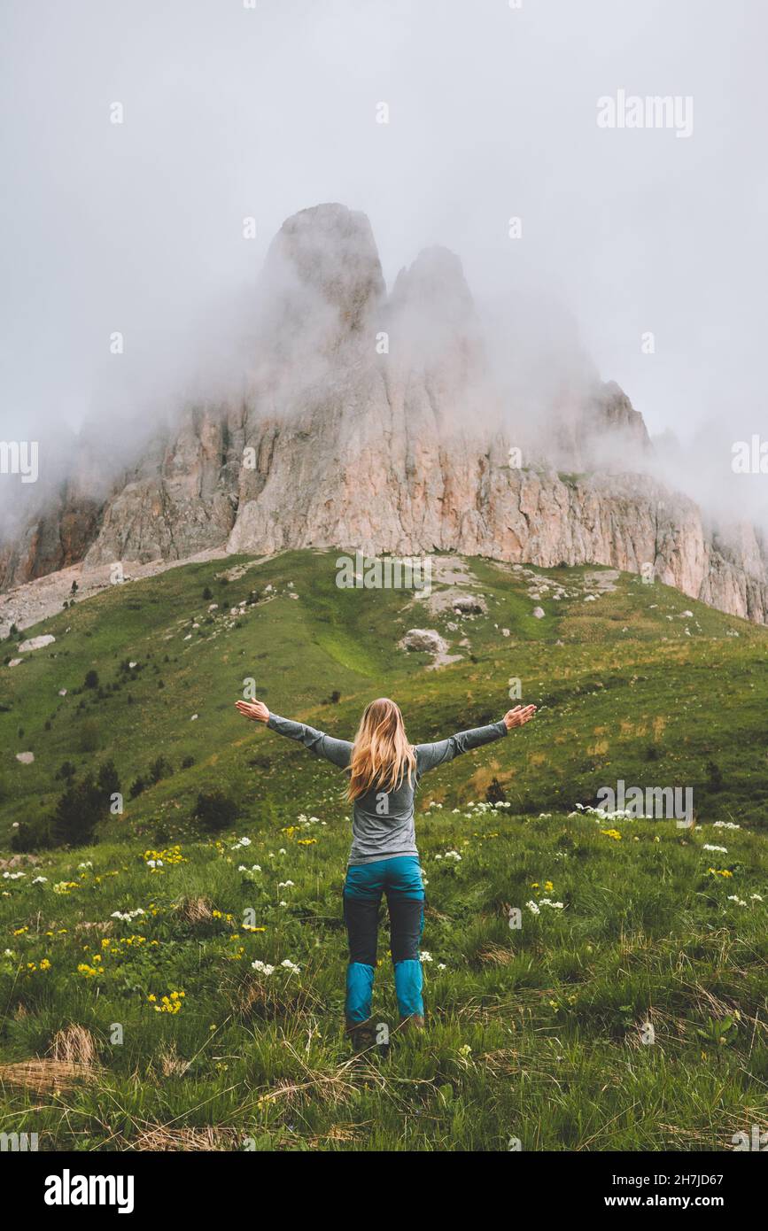 Traveler woman hiking solo in foggy mountains happy raised hands travel adventure vacations outdoor healthy lifestyle active weekend wanderlust concep Stock Photo