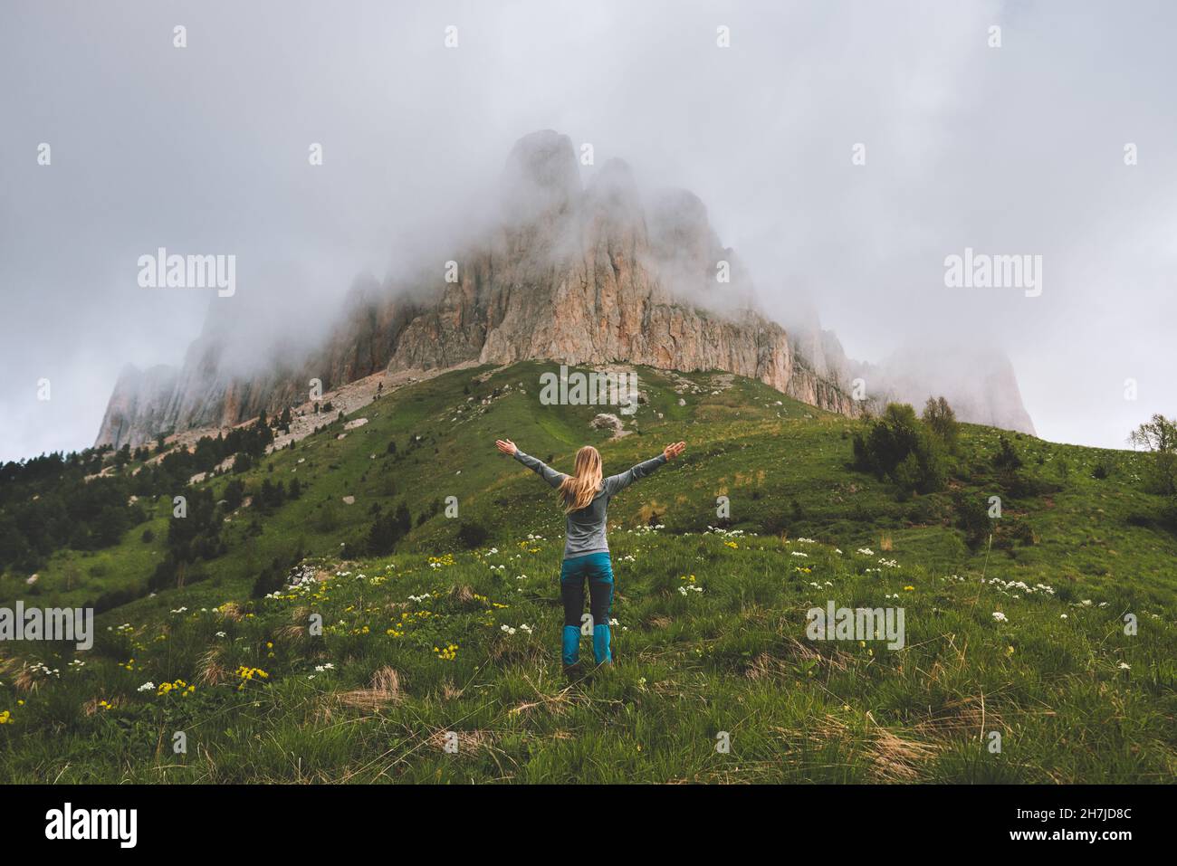 Hiking adventures in foggy mountains woman hiker raised hands travel solo extreme vacations outdoor healthy lifestyle active trip Stock Photo