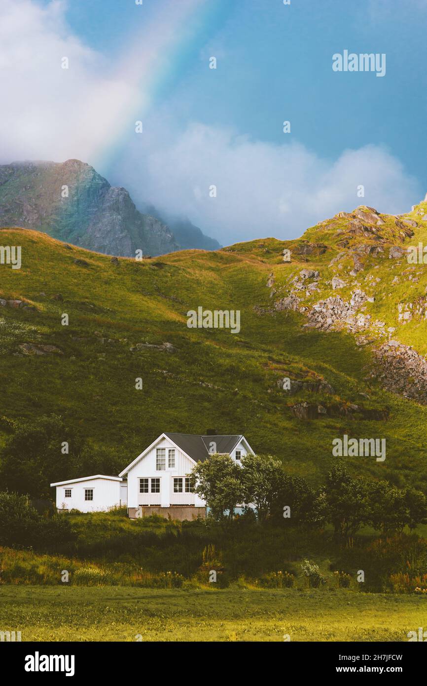Cottage house in mountains and rainbow landscape traditional scandinavian village architecture cozy home Norway Stock Photo
