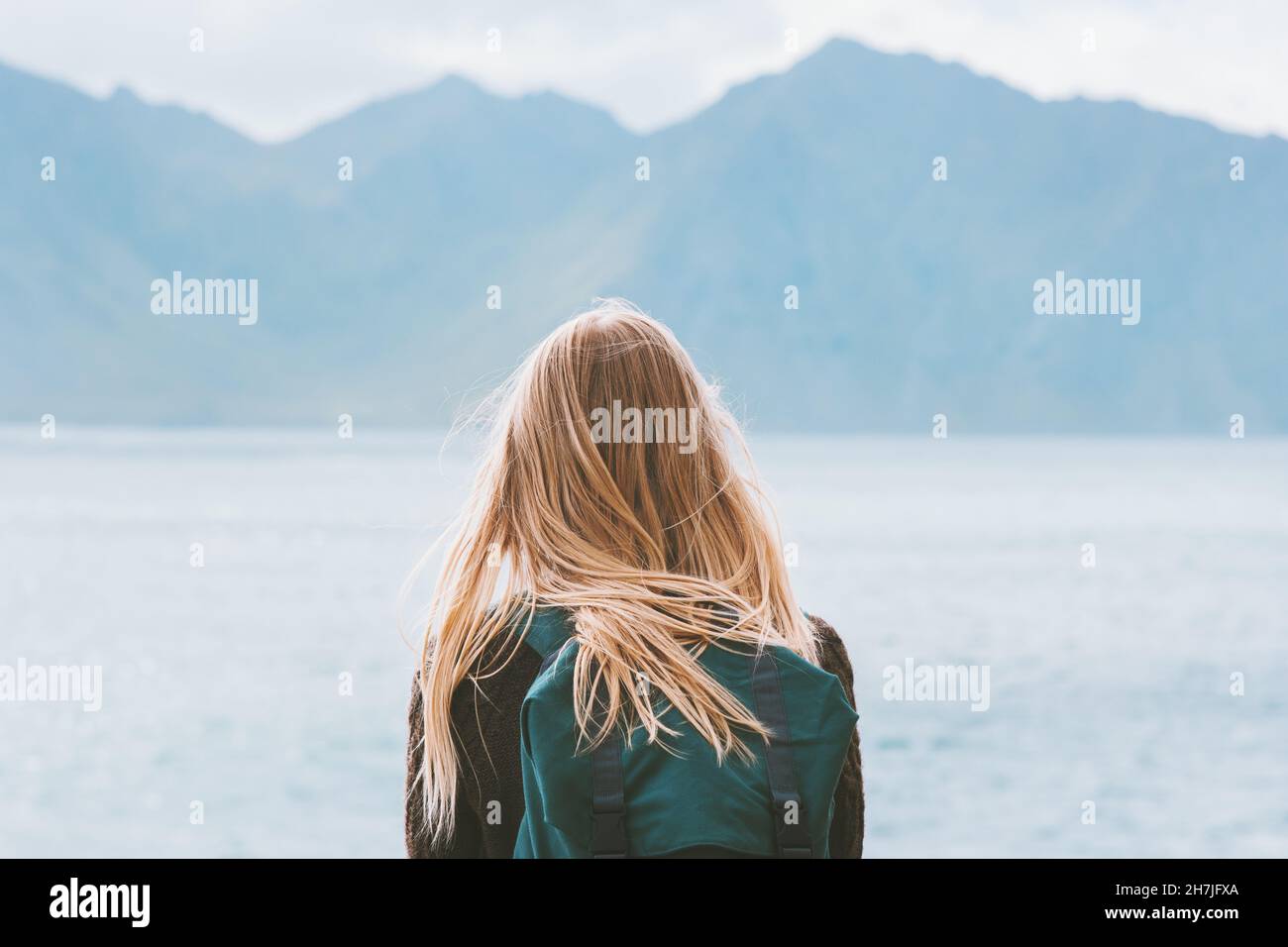 Travel in Norway globetrotter woman with backpack looking at mountains view alone outdoor active vacations adventure lifestyle solo trip Stock Photo