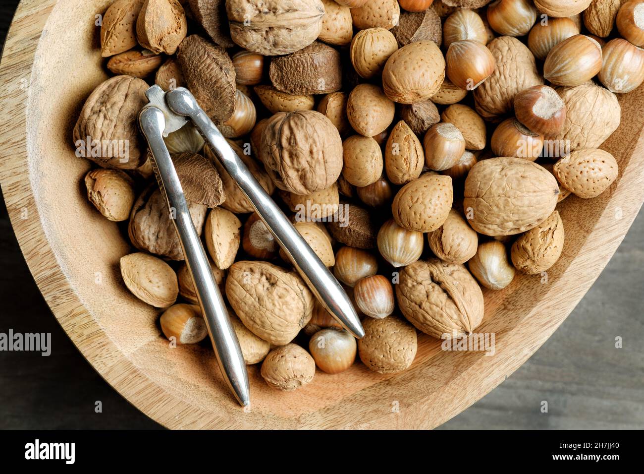 A wooden bowl full of traditional Christmas nuts in shells. An old