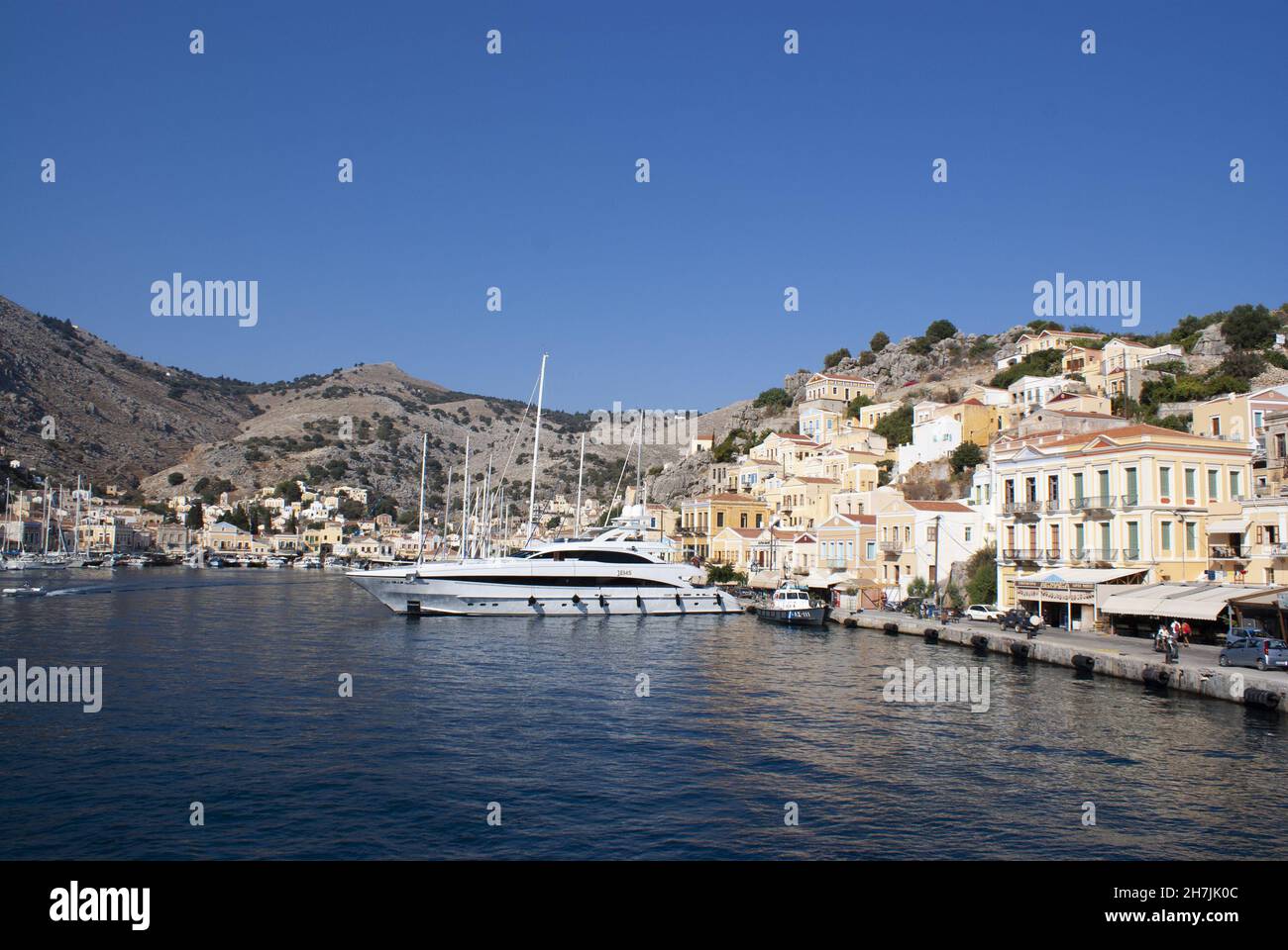 Symi island - Greece - August 19 2009 :  Beautiful harbor scene with bustling colorful waterfront.  Elegant houses line the busy harbor. Landscape asp Stock Photo
