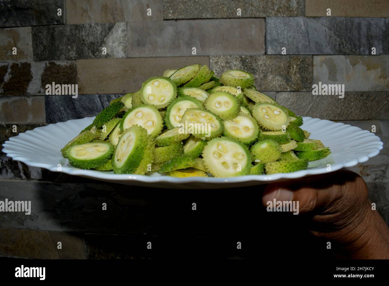Female holding plate of Spiny gourd vegetable also known as Spine