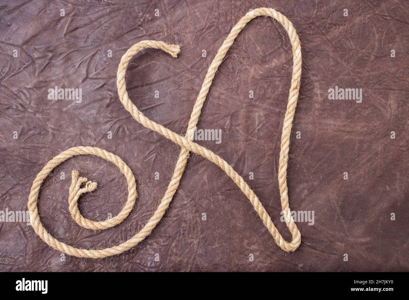 Capital letter A written with jute rope, on textured natural leather Stock Photo