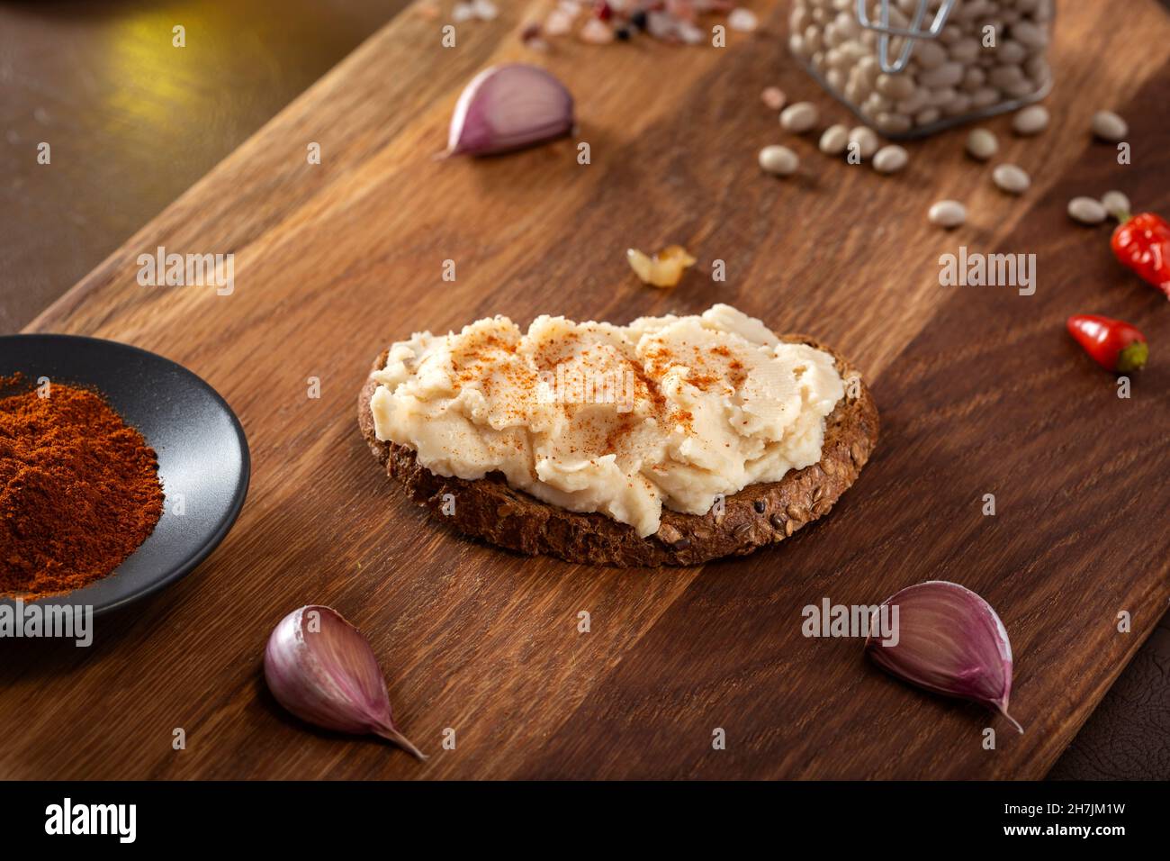 Toast with spread made from mashed boiled beans on wooden background Stock Photo