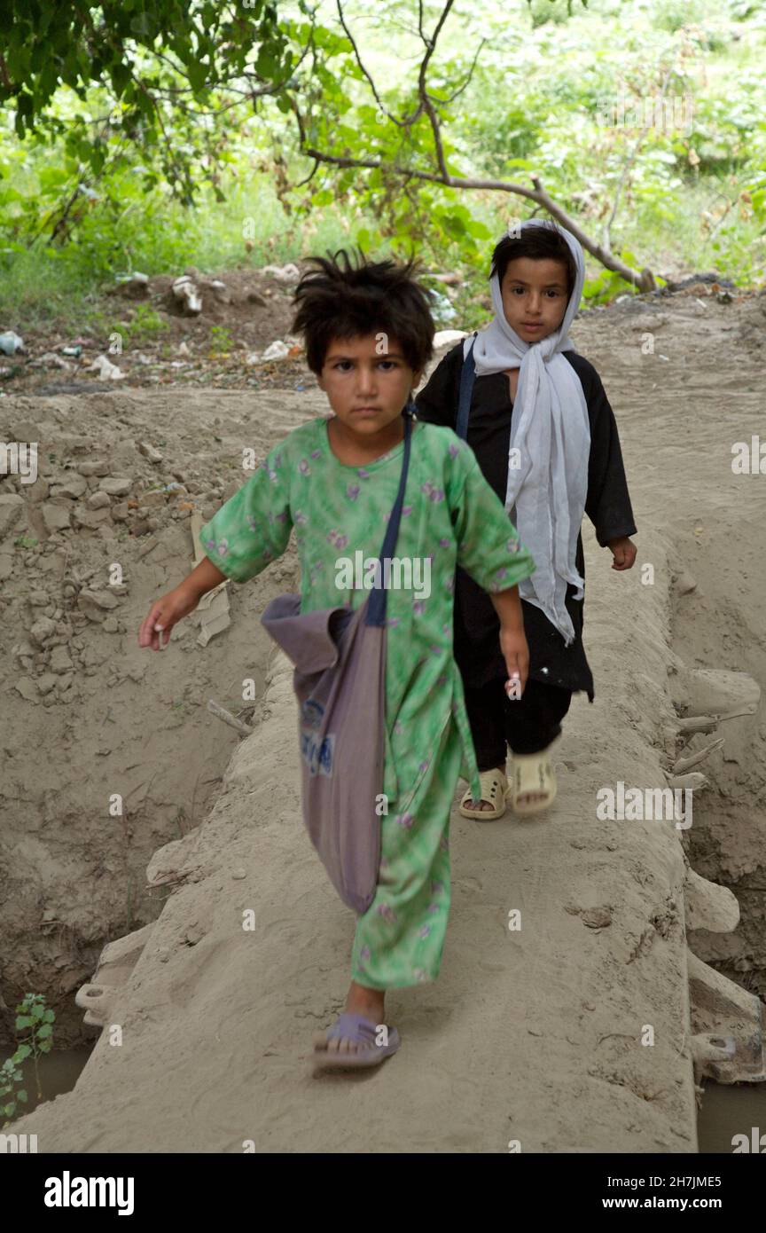 Afghan children walk to a community-based school, in Kamar Kalagh, a village on the outskirts of the north-western city of Heart. As there are no offi Stock Photo