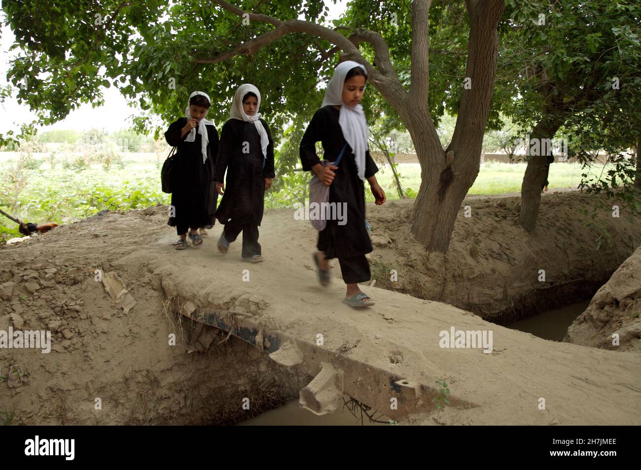 Afghan children walk to a community-based school, in Kamar Kalagh, a village on the outskirts of the north-western city of Heart. As there are no offi Stock Photo
