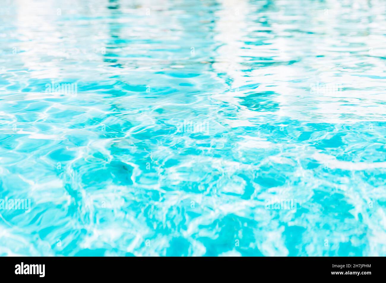 Blue white swimming pool ripped water surface with waves and nice sun sparkles Stock Photo