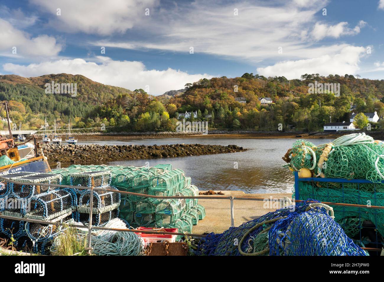 Low tide and colourful fishing nets and lobster pots on the harbour side at Gairloah, Wester Ross, North West Highland, Scotland Stock Photo