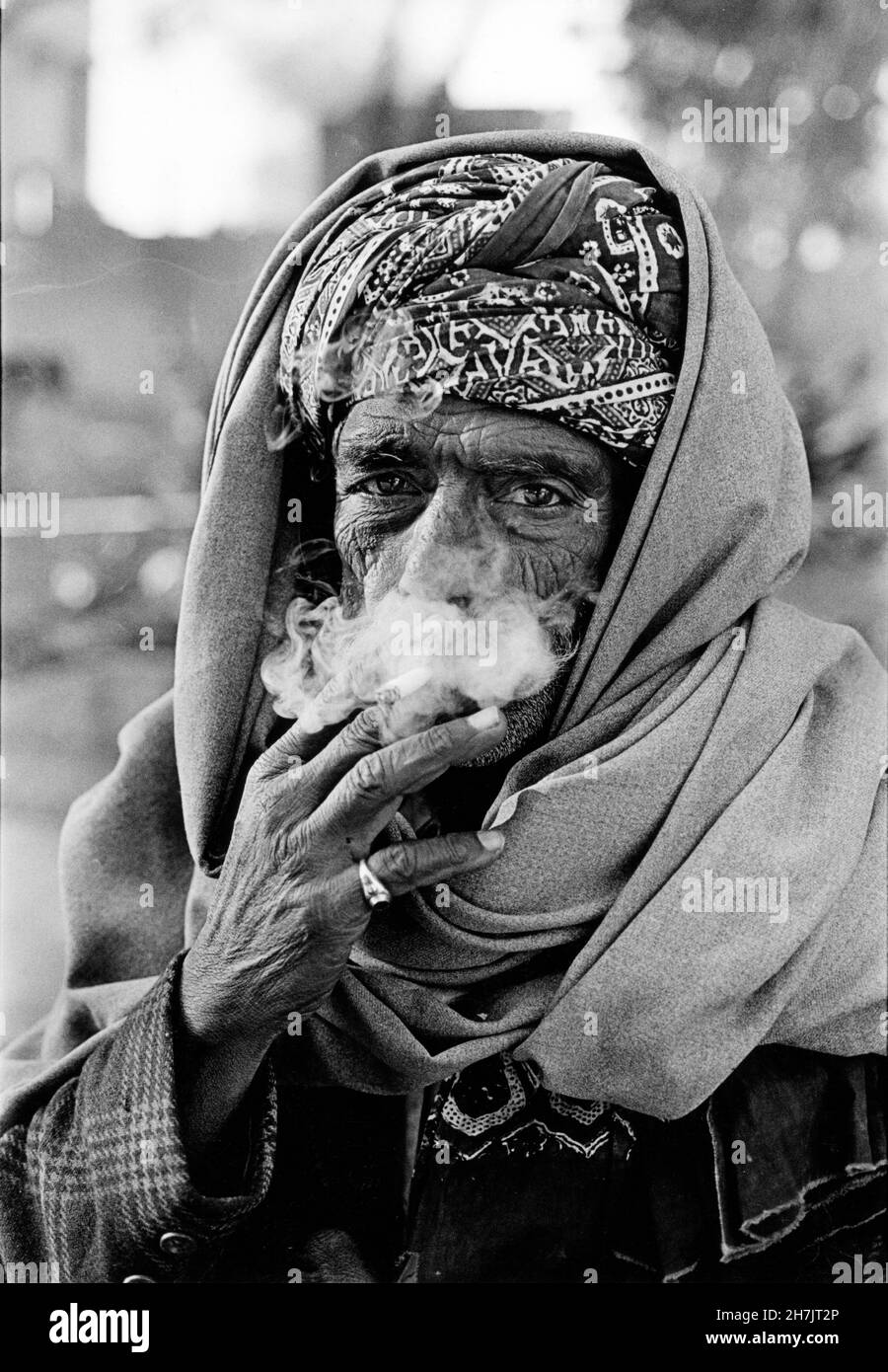 A Sindhi man smokes a cigarette, at a village, in Tharparkar, a desert region, on the border of Rajhistan, in Pakistan. Stock Photo