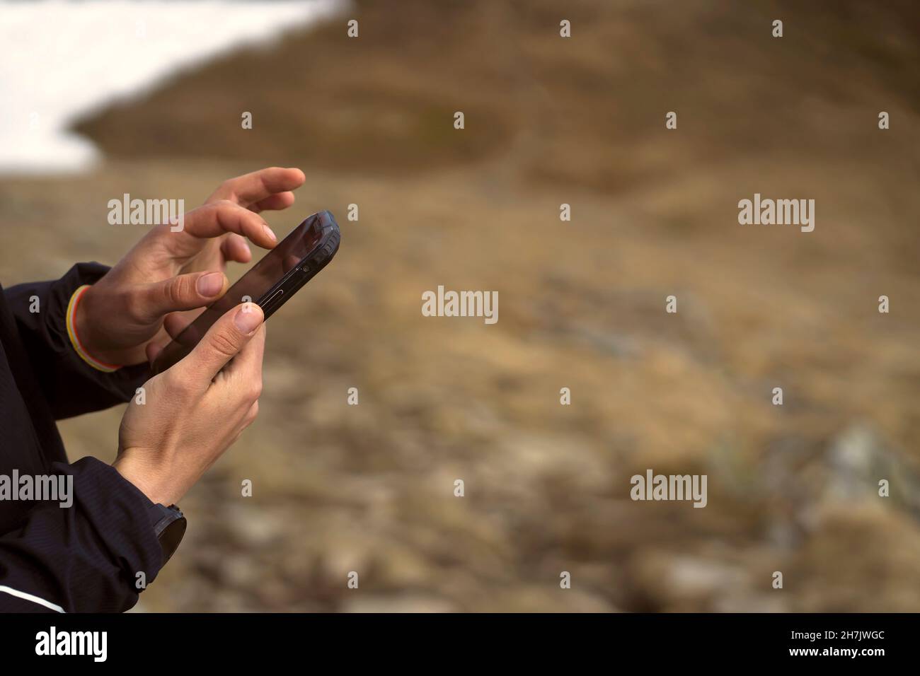 Man holds a smartphone in his hands and looks at a map,  Stock Photo