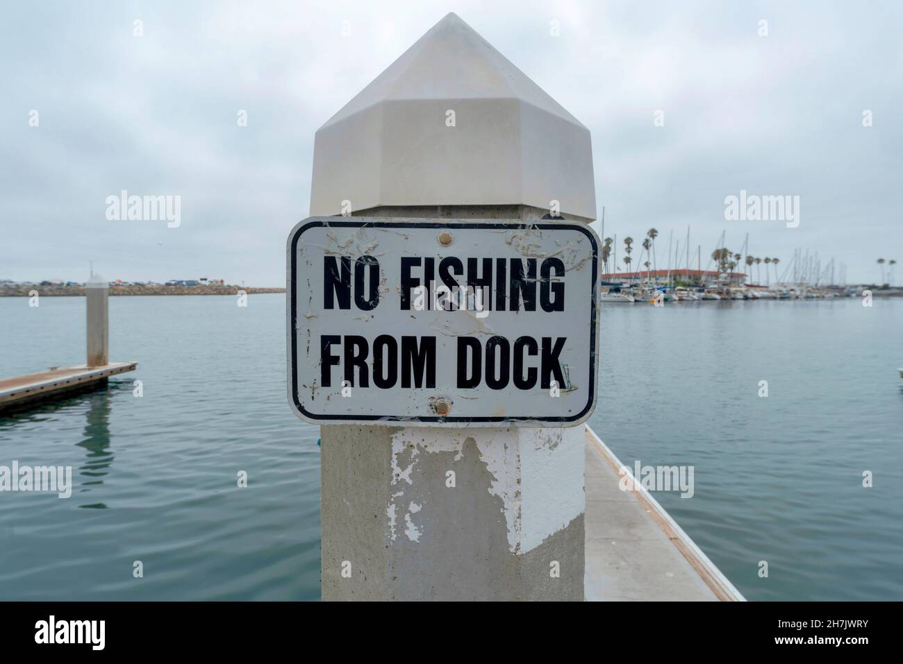 No fishing from dock old signage at Oceanside, California. Close up of a  signage on a post against the view of the water and harbor at the back  Stock Photo - Alamy