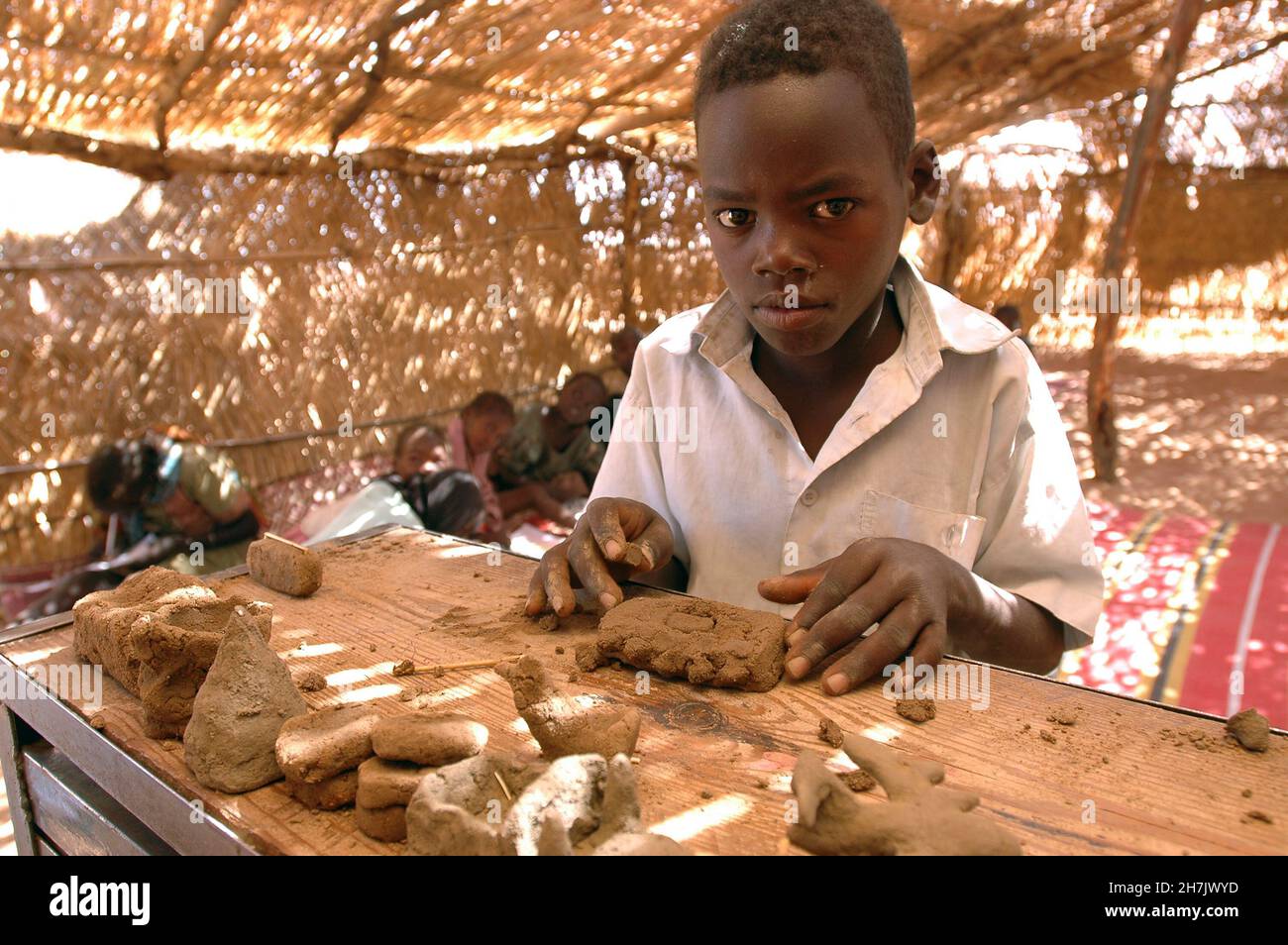 A young boy makes clay toys in a UNICEF supported Safe Play Center in Kalma IDP Camp (Internally Displaced Person) 14 km East of Nyala, South Darfur. Stock Photo