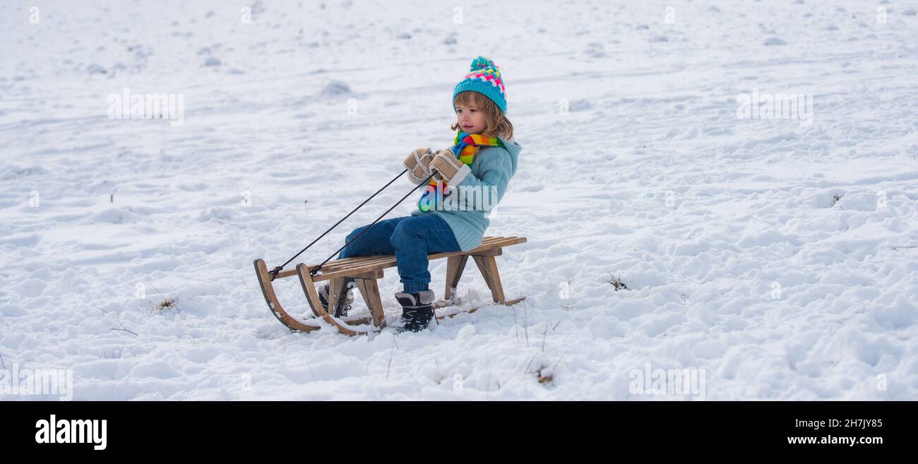 Sledge Riging Happy kids having fun and riding the sledge in the winter snowy forest ...