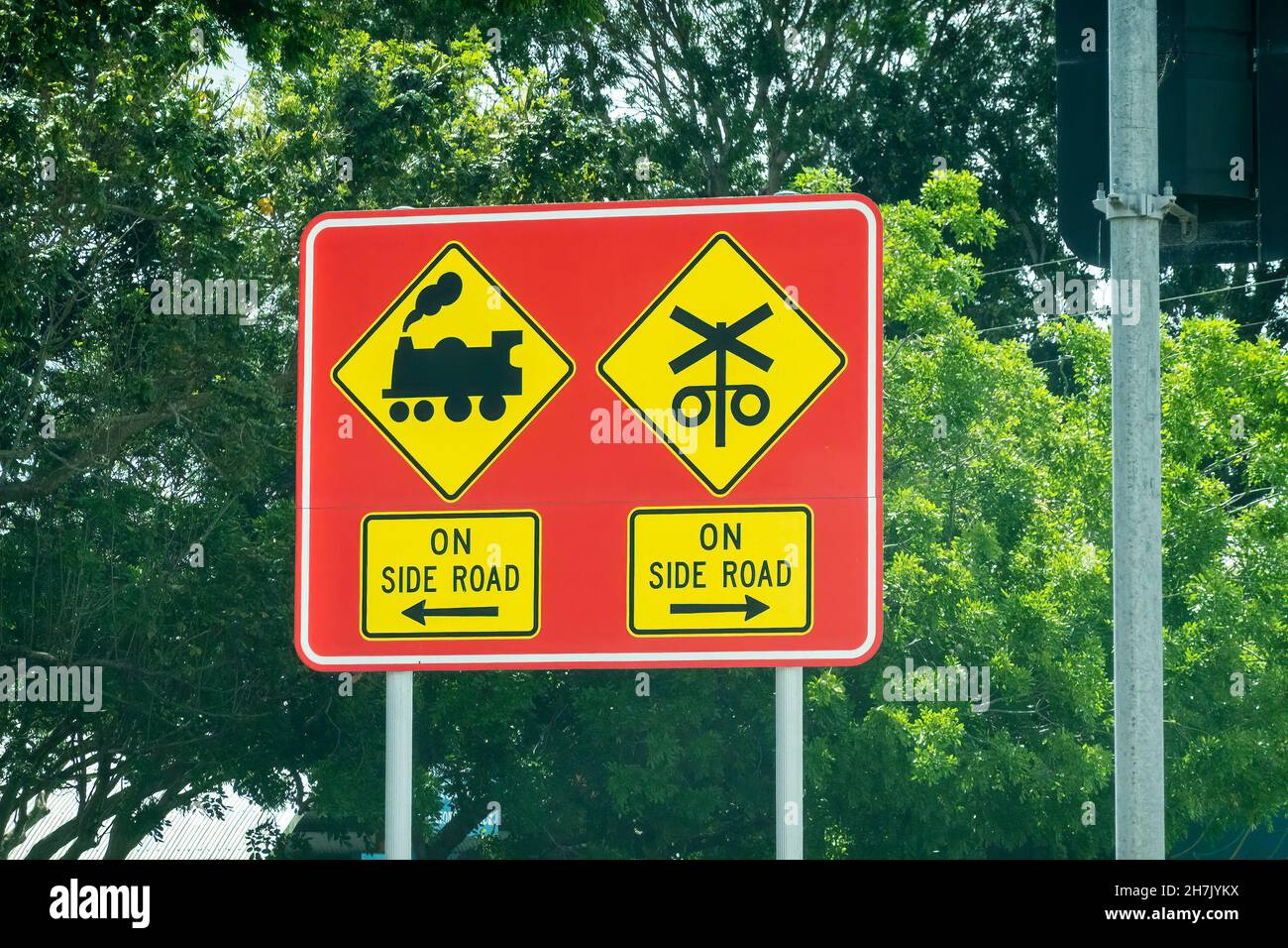 Warning roadside sign about a train crossing on side road, bright and