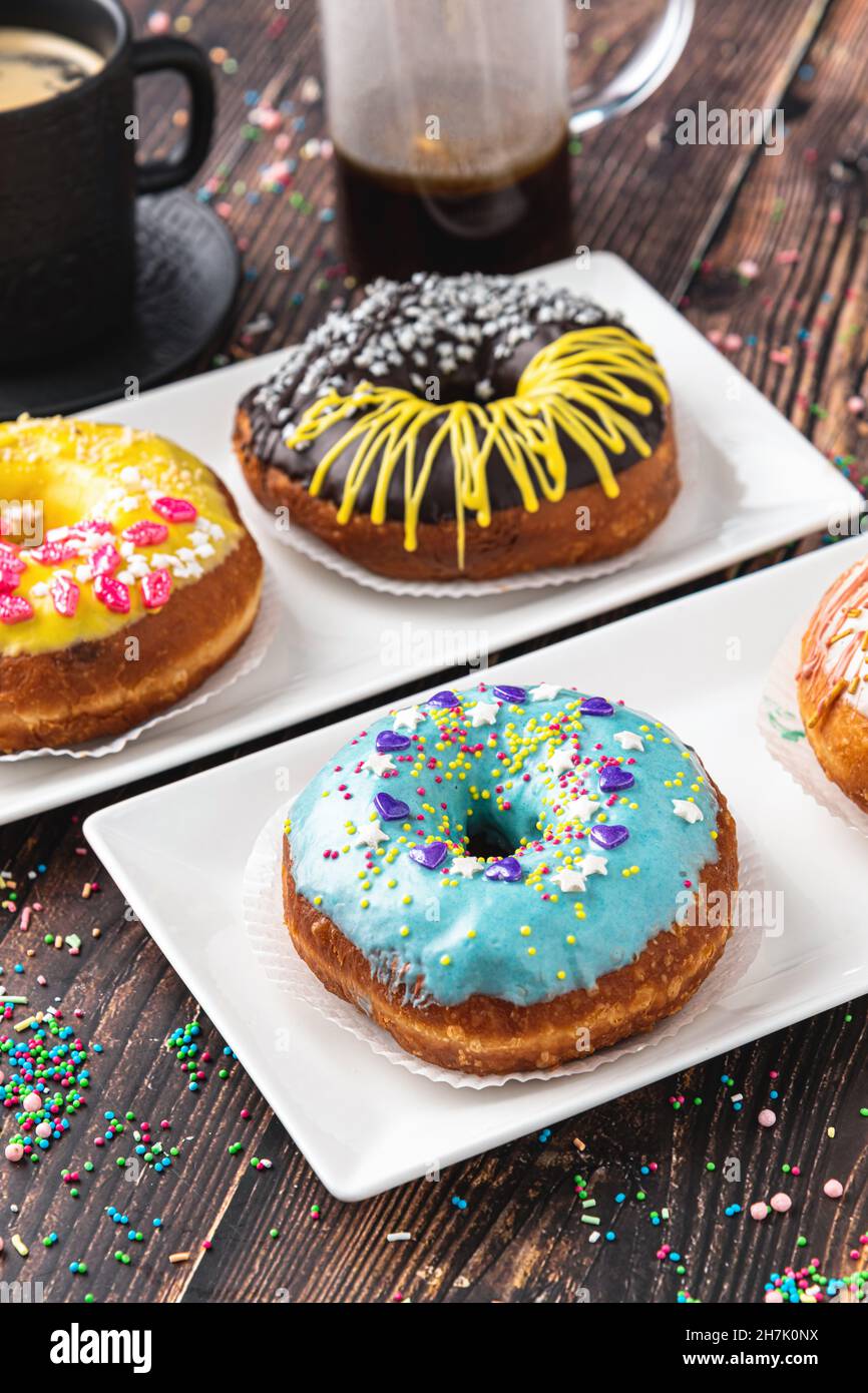 Delicious donuts decorated with different decorations on wooden table Stock Photo