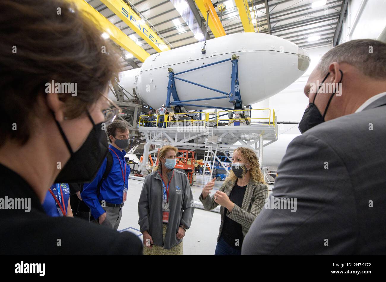NASA Associate Administrator for the Science Mission Directorate Thomas Zurbuchen, right, and other NASA leadership listen as Julianna Scheiman, director for civil satellite missions, SpaceX, center, gives a tour of the hanger where the Falcon 9 rocket and DART spacecraft are being readied for launch, Monday, Nov. 22, 2021, at Vandenberg Space Force Base in California. DART is the world's first full-scale planetary defense test, demonstrating one method of asteroid deflection technology. The mission was built and is managed by the Johns Hopkins APL for NASA's Planetary Defense Coordination Off Stock Photo