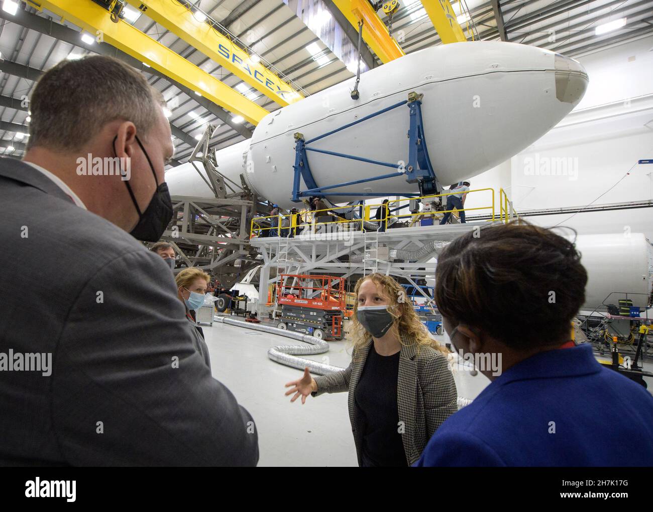 NASA Associate Administrator for the Science Mission Directorate Thomas Zurbuchen, left, and other NASA leadership listen as Julianna Scheiman, director for civil satellite missions at SpaceX, center, gives a tour of the hanger where the Falcon 9 rocket and DART spacecraft are being readied for launch, Monday, Nov. 22, 2021, at Vandenberg Space Force Base in California. DART is the world's first full-scale planetary defense test, demonstrating one method of asteroid deflection technology. The mission was built and is managed by Johns Hopkins APL for NASA's Planetary Defense Coordination Office Stock Photo