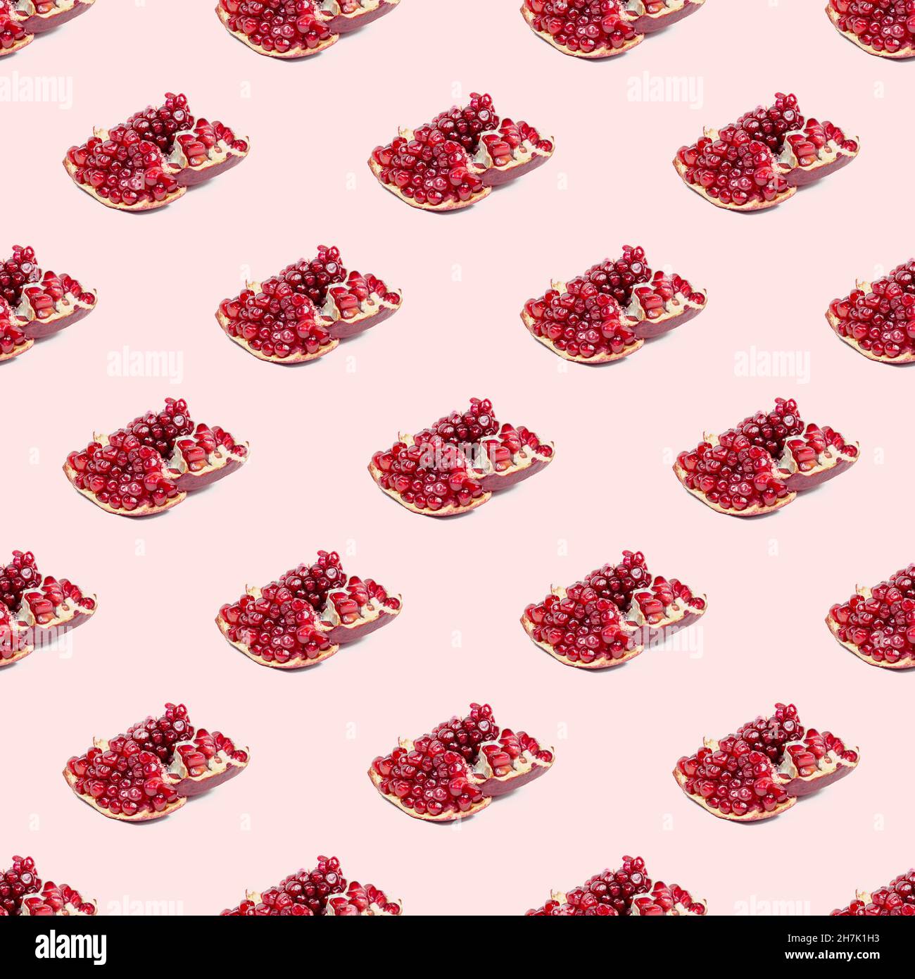 Bright red pomergranate pieces repeat seamless pattern on light pink background. Stock Photo