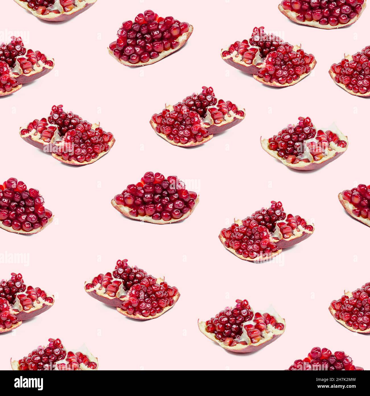 Bright red pomergranate pieces repeat seamless pattern on light pink background. Stock Photo