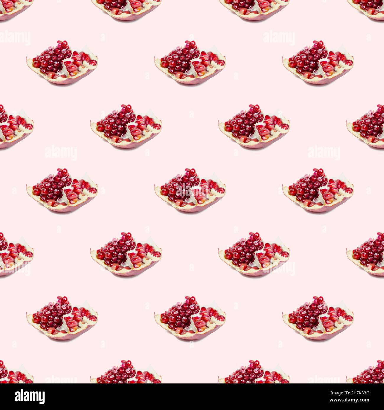 Bright red pomergranate pieces repeat seamless pattern on light pink background. Stock Photo