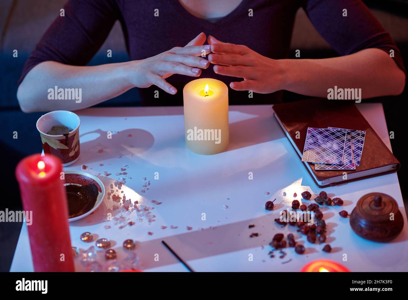 Mysterious woman practicing magic using candlelight Stock Photo