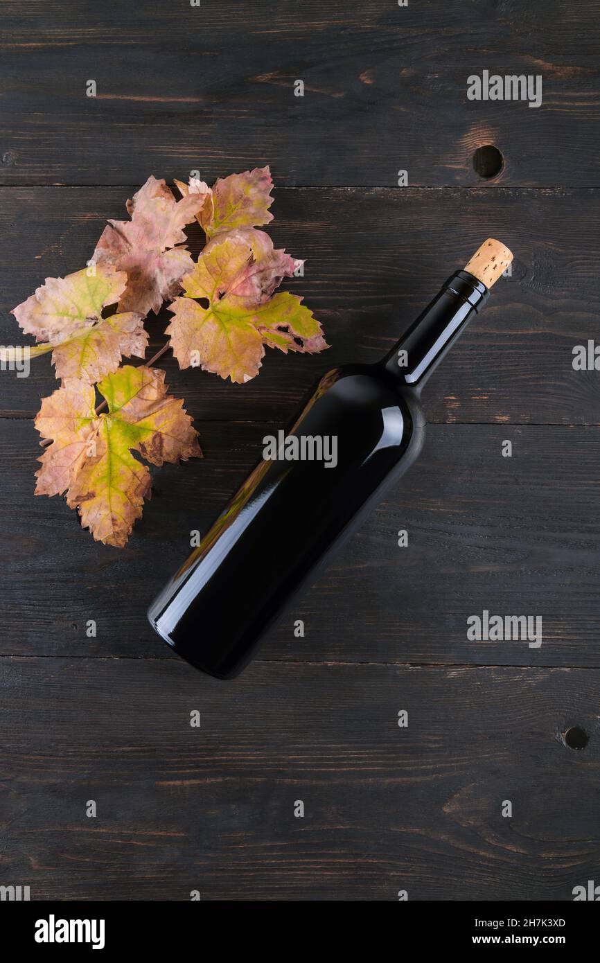 Top view of bottle of red wine fall grapes leaves a on dark wooden background, concept of traditional red wine flat lay background Stock Photo