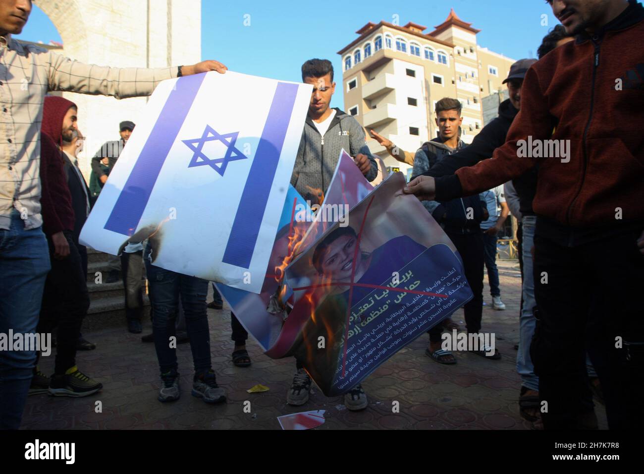 Rafah, Gaza. 23rd Nov, 2021. Palestinians burn Israel's flag and posters depicting the crossed-out face of Britain's Home Secretary Priti Patel during a rally against Britain's possible designation of Hamas as a terror group, in Rafah in the southern Gaza Strip, on Tuesday, November 23, 2021. The United States designated Hamas as a terror group in 1995. Photo by Ismael Mohamad/UPI Credit: UPI/Alamy Live News Stock Photo