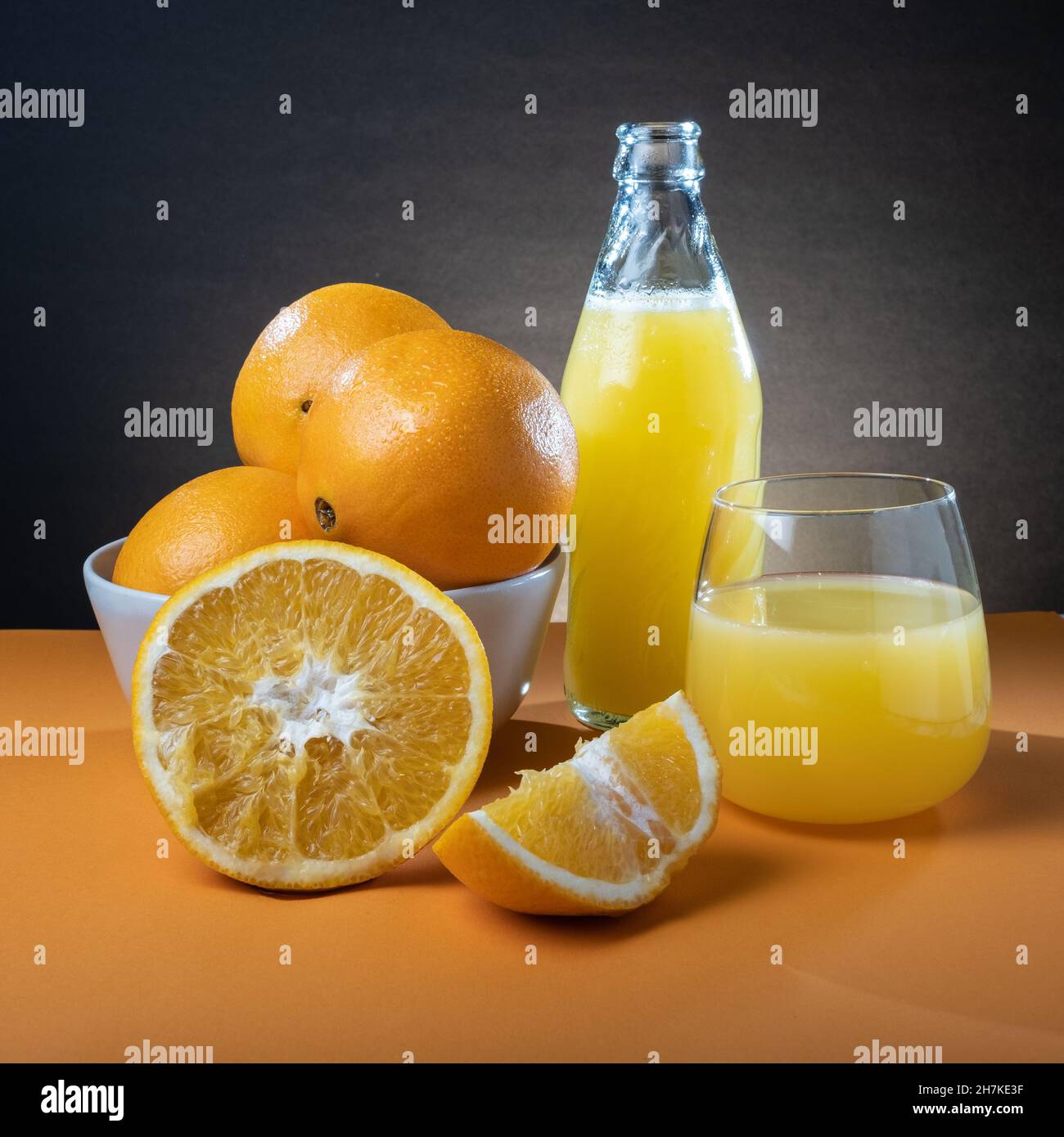 https://c8.alamy.com/comp/2H7KE3F/helsinki-finland-closeup-of-moist-oranges-and-glass-bottle-of-orange-juice-on-the-table-2H7KE3F.jpg