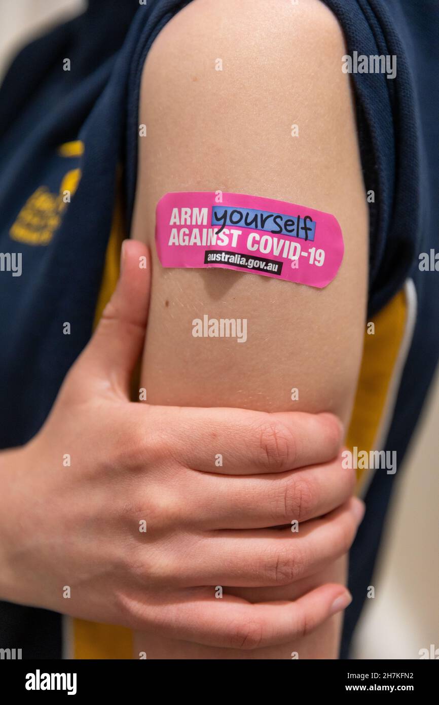 13 year old girl with branded vaccination band aid, Melbourne, Australia Stock Photo