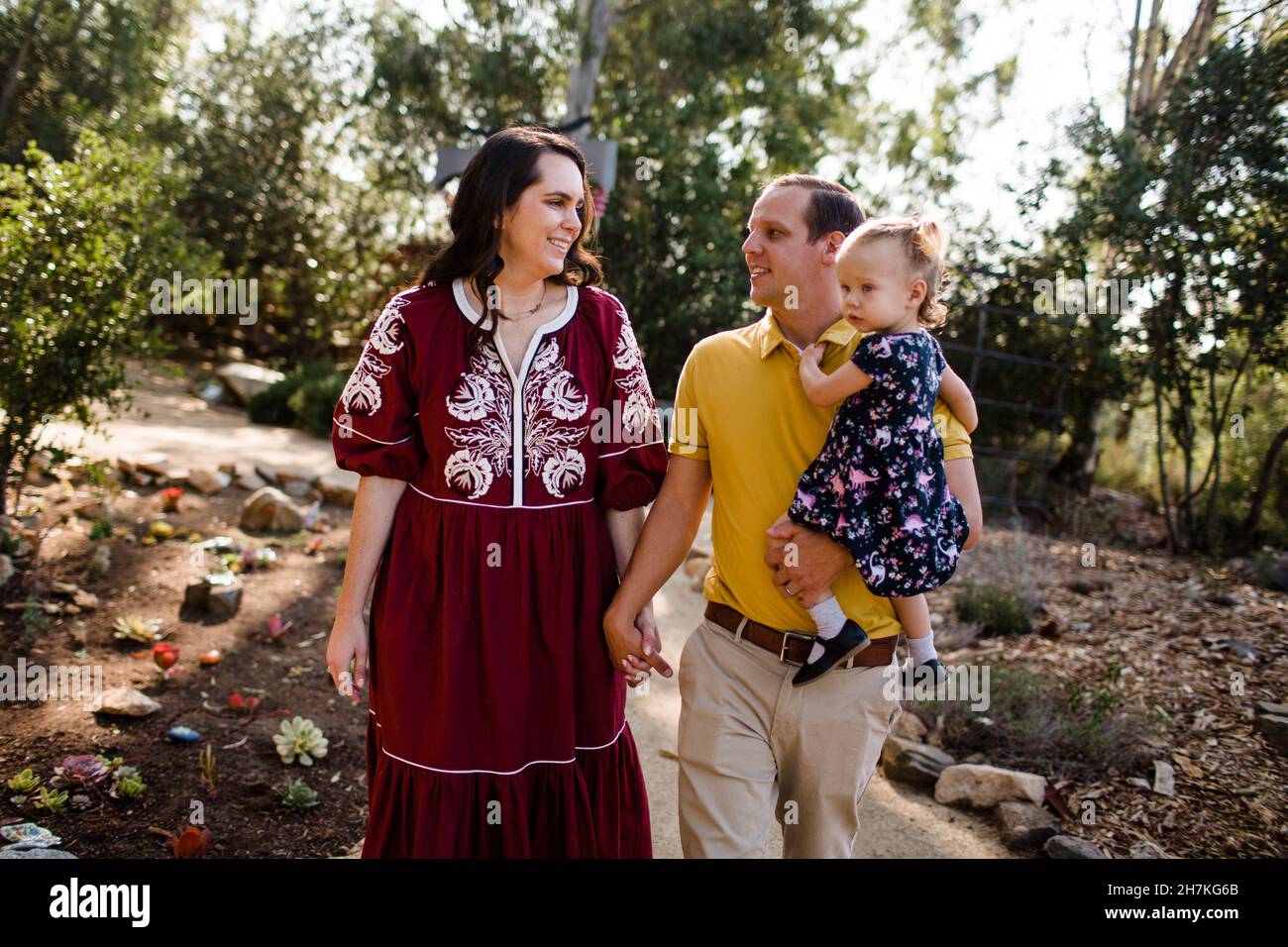 Family of Three Walking Through Garden in California Stock Photo