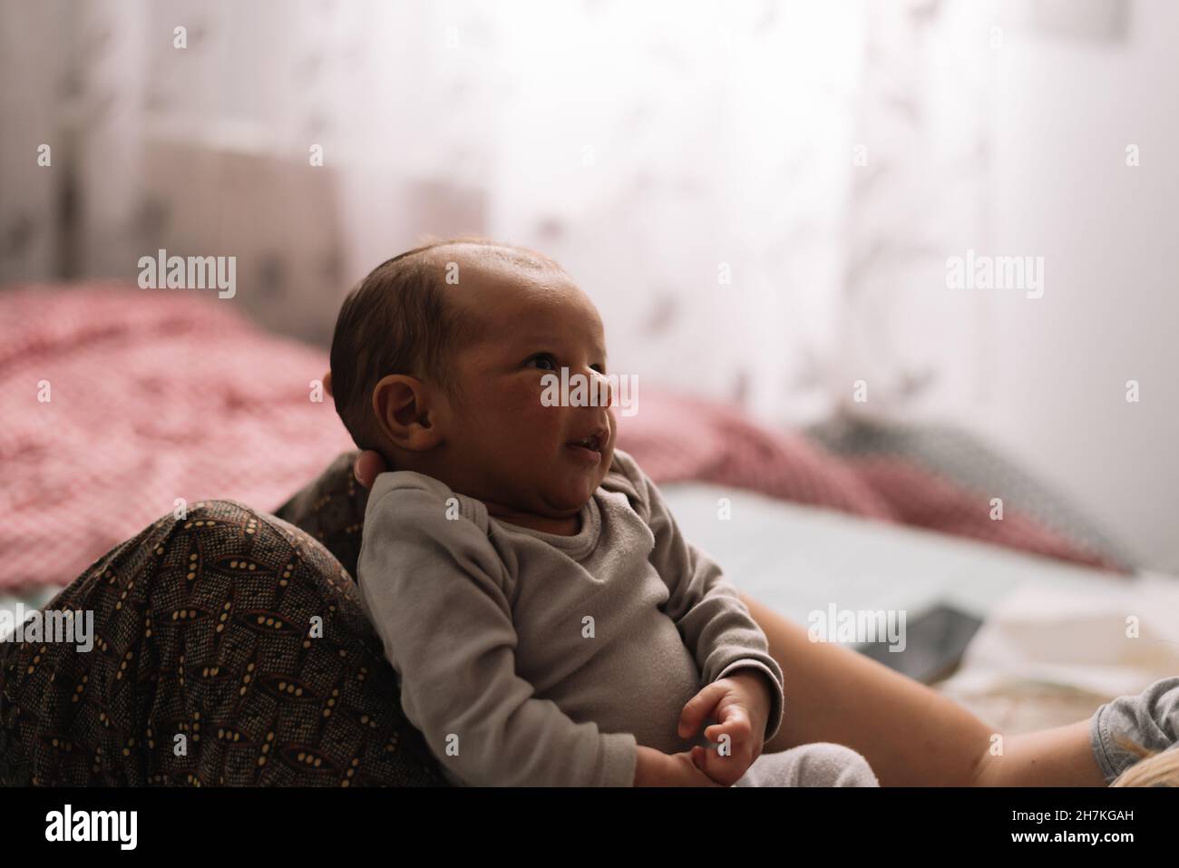 Mother holding her newborn baby between her knees Stock Photo Alamy