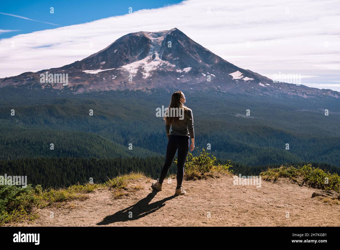 Female standing on cliff with Mount Adams in the background Stock Photo
