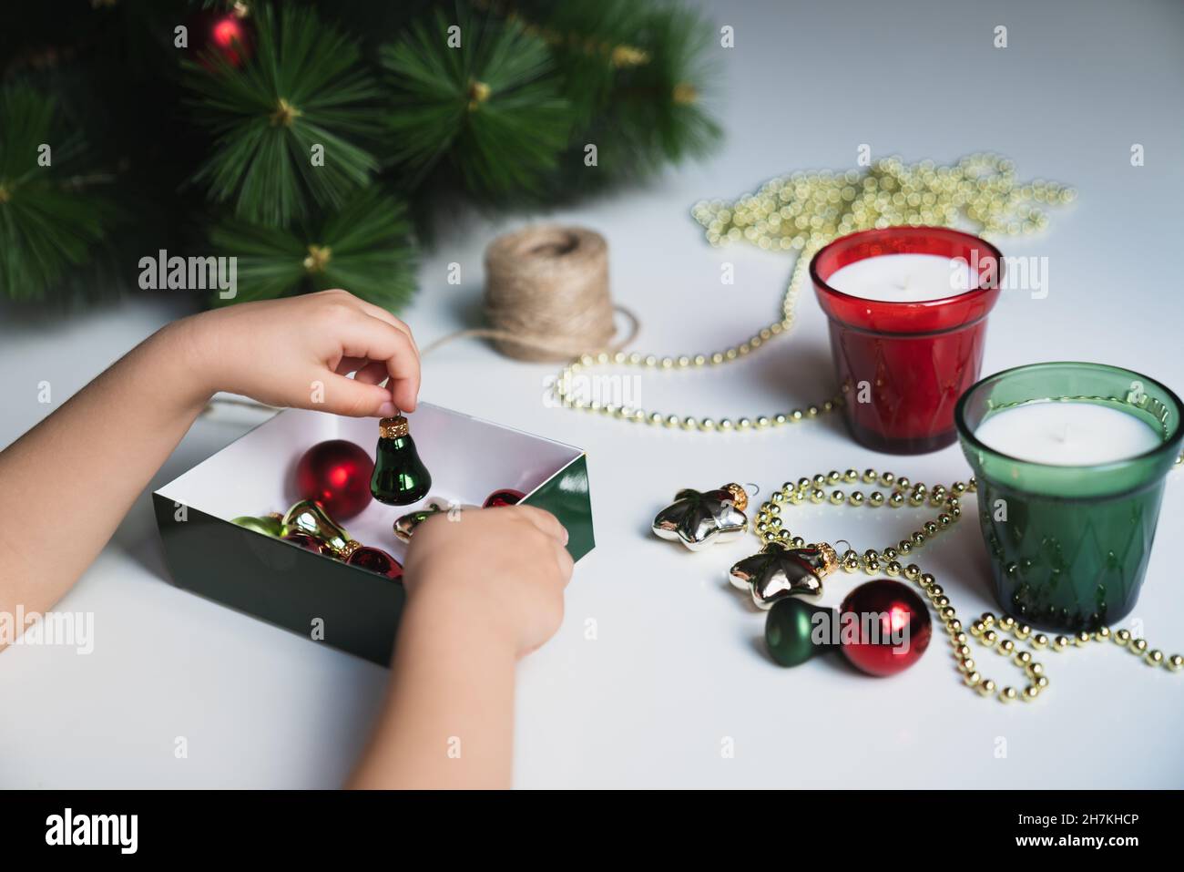 Ð¡ropped hands of a child taking out christmas decorations from a box Stock Photo