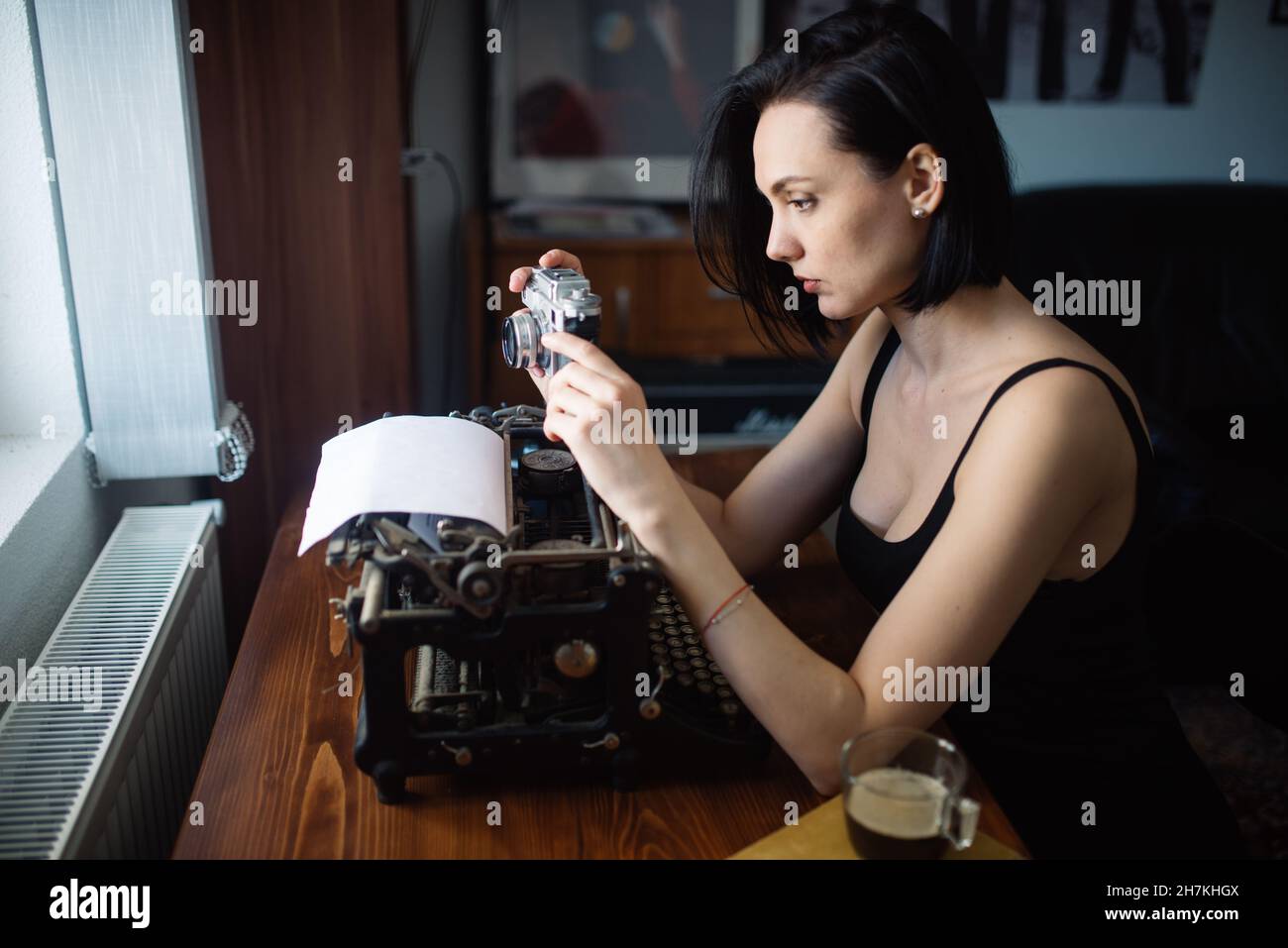 Beautiful woman taking a film photo at home. Stock Photo