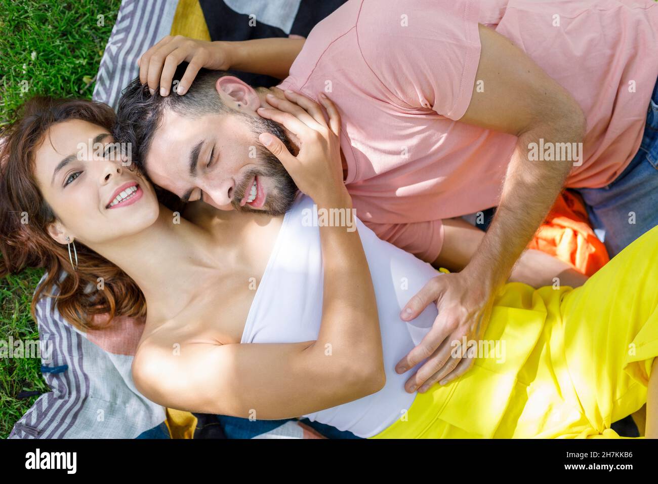 Thoughtful couple holding hands while relaxing on picnic blanket Stock Photo