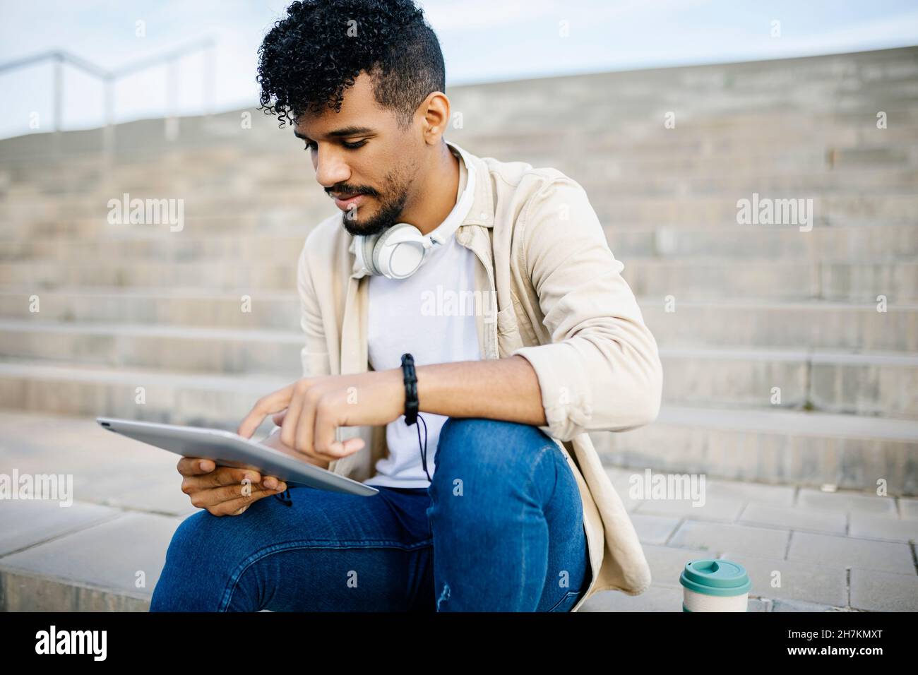 Man using digital tablet while sitting on steps Stock Photo