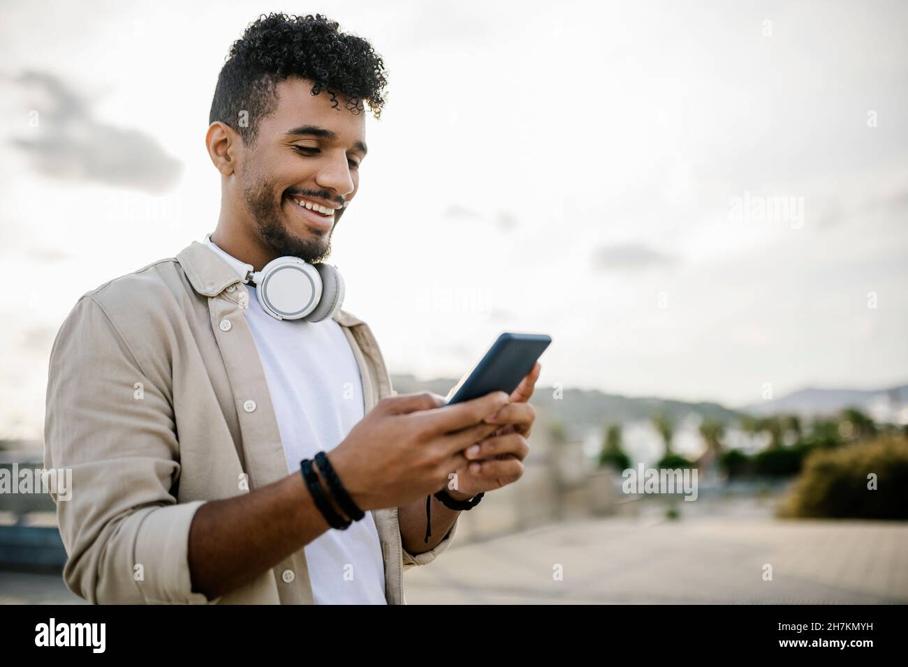 Happy man with wireless headphones using smart phone Stock Photo