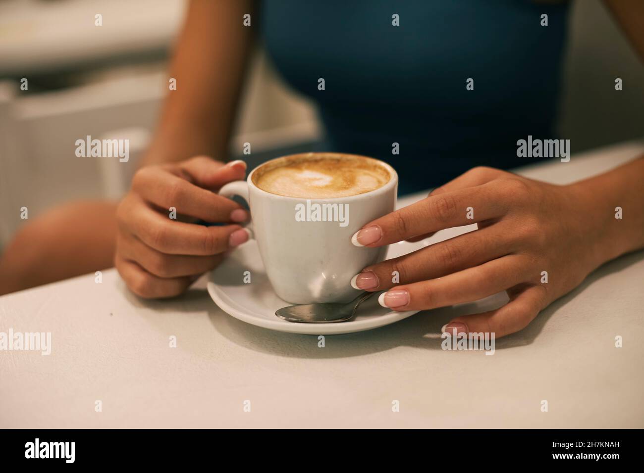 Young woman with manicured nails having coffee at cafe Stock Photo