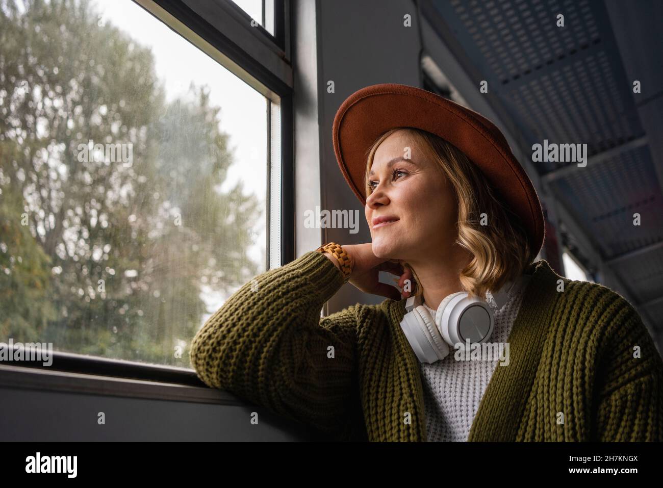 Woman looking through window while travelling in train Stock Photo