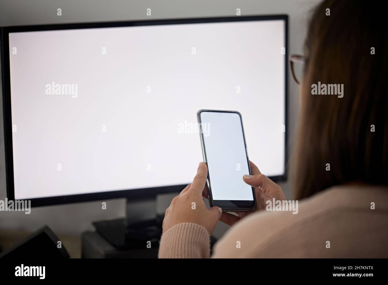 Female freelancer using mobile phone while working at home Stock Photo