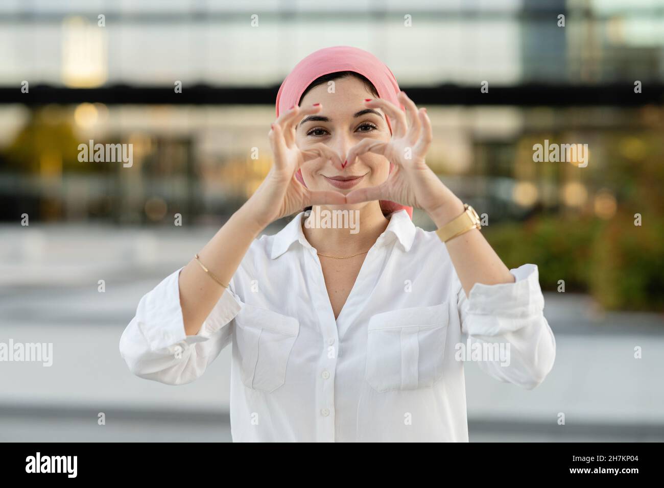 Young woman wearing headscarf with hands behind head Stock Photo