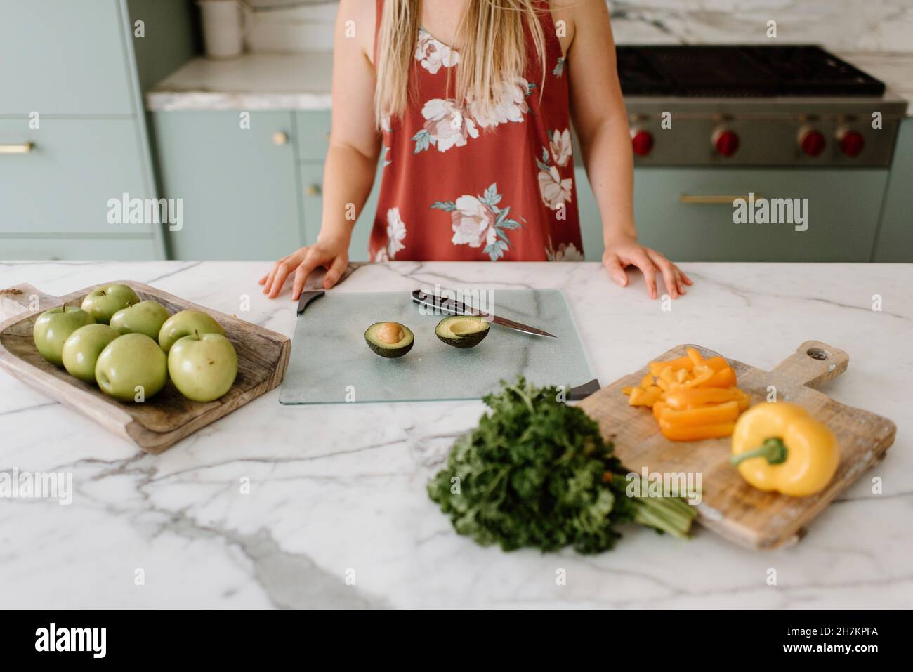 Female nutrient coach with vegetables and fruits at kitchen counter Stock Photo