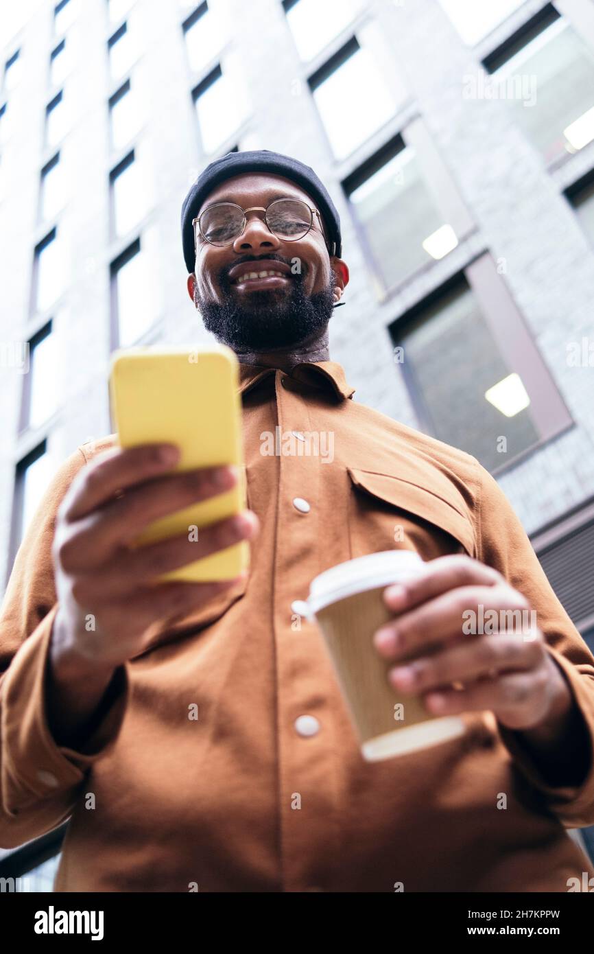 Smiling man using smart phone Stock Photo